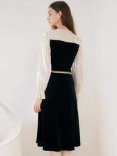 back view of a lady in black midi velvet dress
